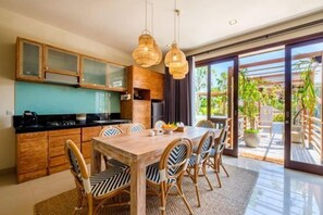 A modern kitchen with wooden cabinets and a dining area with a wooden table and chairs.