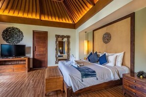 Quarto com cama, mesas de cabeceira, televisão e teto de madeira.