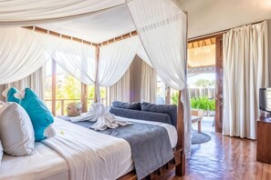 Ein Zimmer mit Himmelbett, Fernseher und Blick ins Freie.