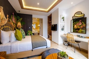 A modern bedroom with a bed, desk, and seating area.