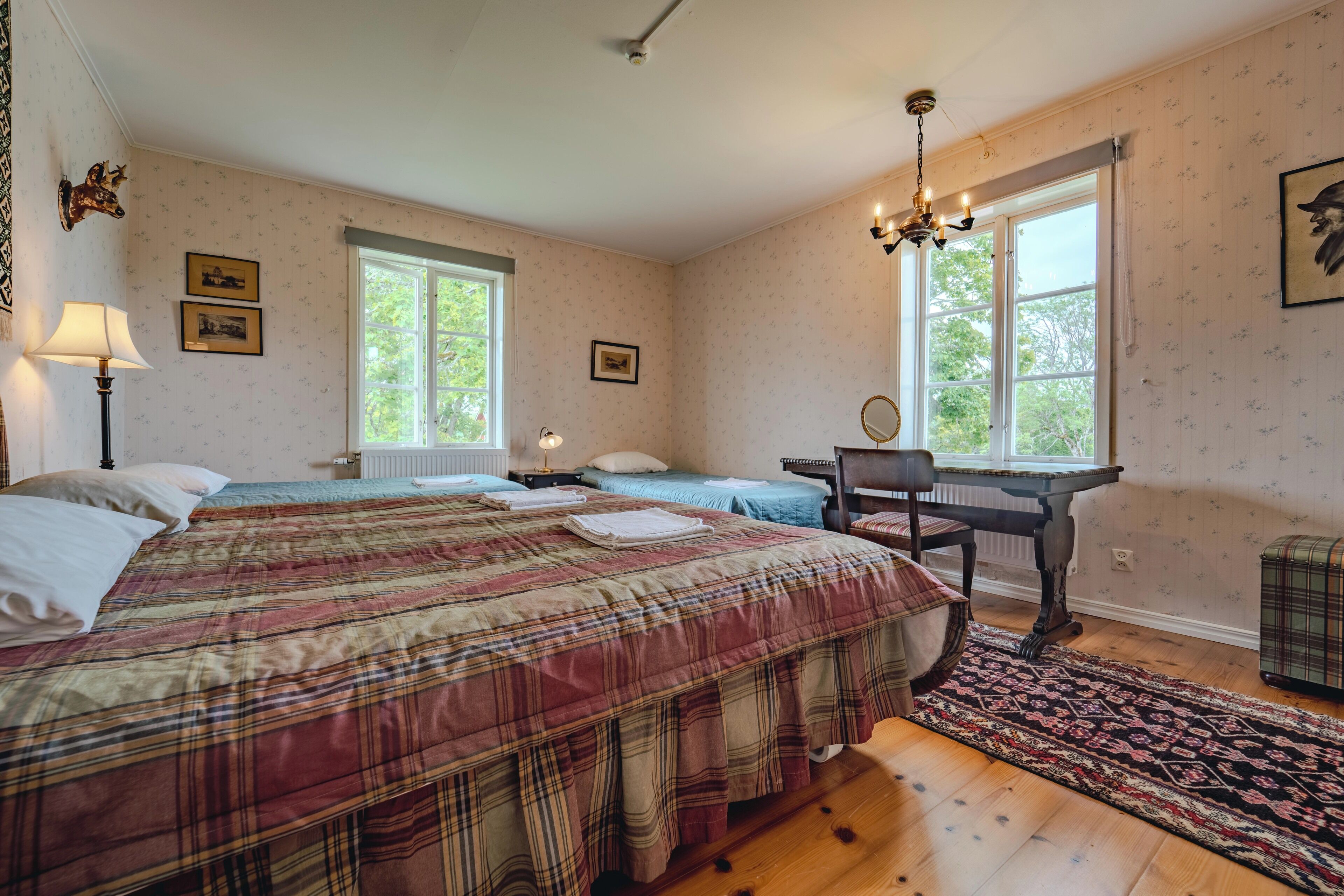 Una camera da letto con un letto grande, due finestre, una scrivania e una sedia.