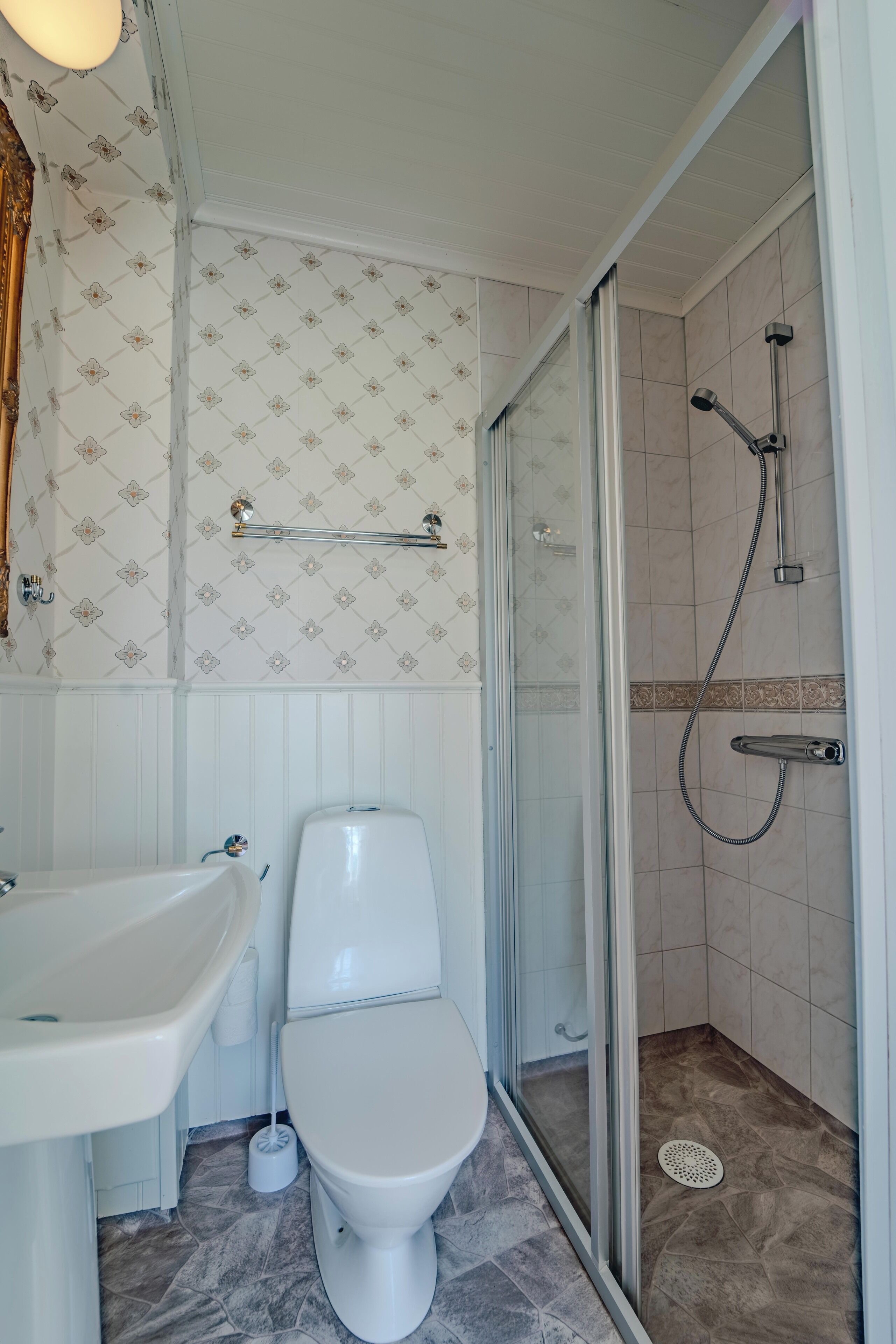 Een badkamer met toilet, wastafel en douche.