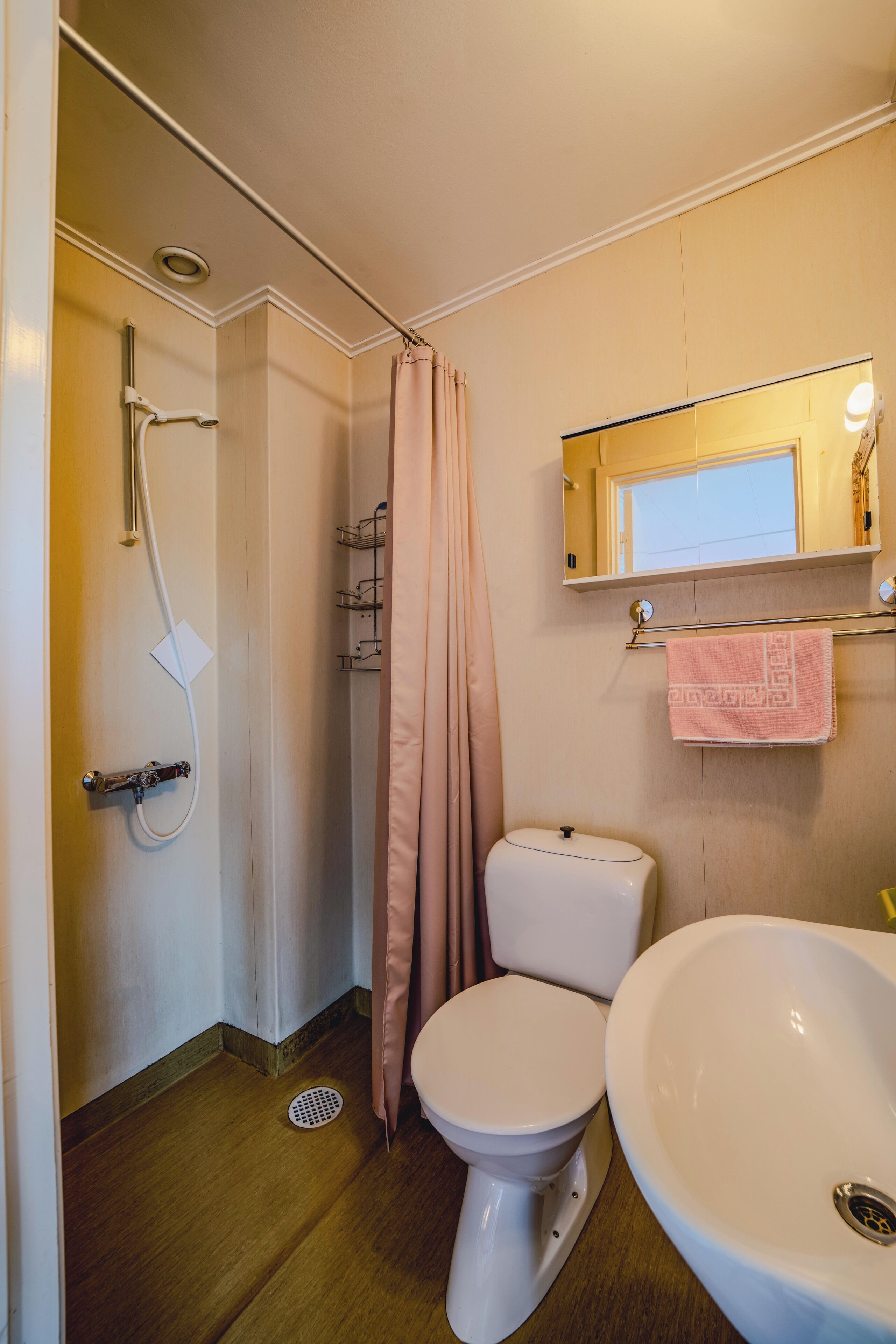 A bathroom with a shower, toilet, and sink.