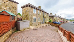 A row of stone terraced houses with a paved walkway and a wooden fence. - Incredible Home | 3Bedrooms | Driveway | Sleeps 6 (Lancashire)