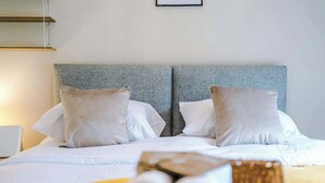 A hotel room with a bed, two pillows, a bedside table, and a lamp. - Incredible Home | 3Bedrooms | Driveway | Sleeps 6 (Lancashire)