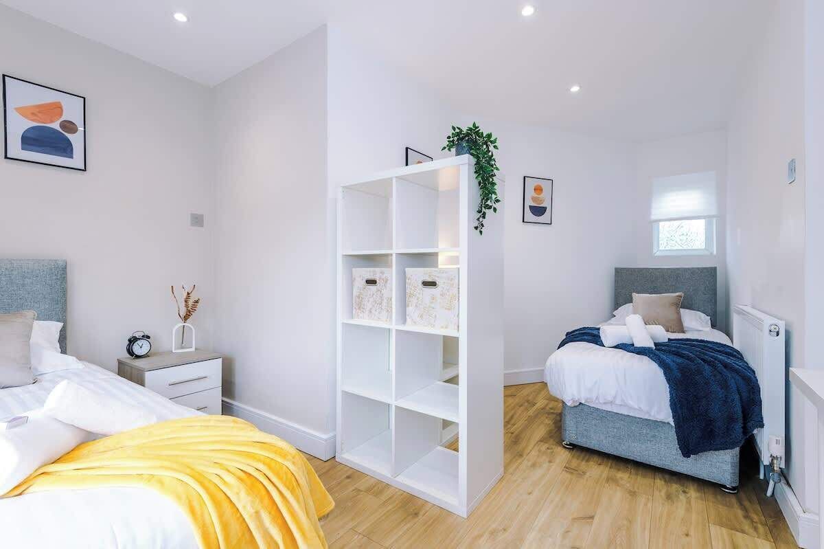 Un dormitorio moderno con cama, mesita de noche y armario con cajas de almacenamiento.