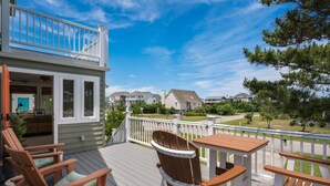 Une terrasse dotée de mobilier d’extérieur, d’une rambarde et offrant une vue sur un quartier résidentiel.
