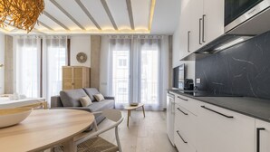 Une cuisine moderne avec des armoires blanches, un comptoir noir et un four encastré.