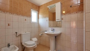 A bathroom with a toilet, bidet, sink, and a window. - Krknjasi - Double Bedroom (Drvenik Veliki)