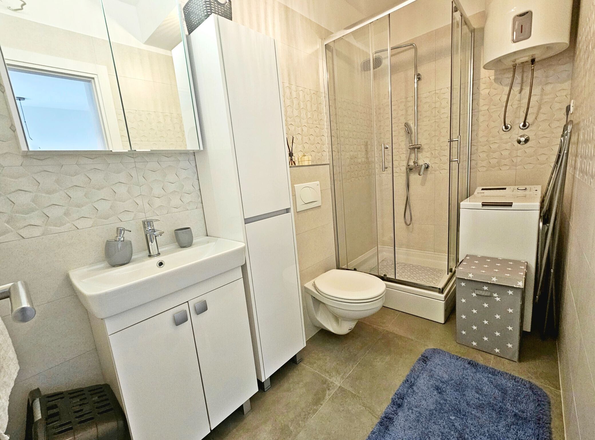 A modern bathroom with a glass-enclosed shower, a toilet, and a sink with a mirror above.