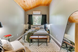 A bedroom with a bed, bedside tables, a bench, a mirror, and a window with curtains. - [City] Farm w/ 120 Acres, Mtn & Water Views! (Damascus)