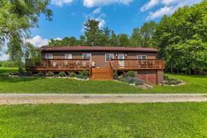 A two-story house with a deck, a garage, and a well-maintained lawn. - [City] Farm w/ 120 Acres, Mtn & Water Views! (Damascus)
