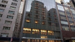 A modern high-rise building with a glass facade, surrounded by other tall buildings. - New York City | Midtown Escape | Near Central Park & Broadway (New York)