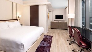 A hotel room with a bed, a desk, two chairs, a television, and a window. - New York City | Midtown Escape | Near Central Park & Broadway (New York)