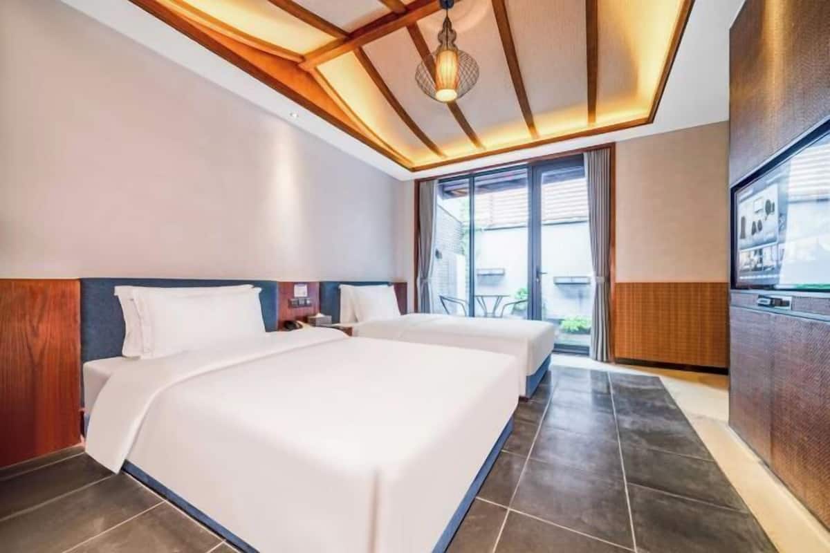 Habitación de hotel con una cama grande, un escritorio y vistas al exterior.