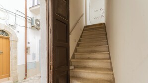 A narrow stairway with a wooden door and a metal handrail. - Residenza Vico Recupero by Wonderful Italy (Polignano a Mare)