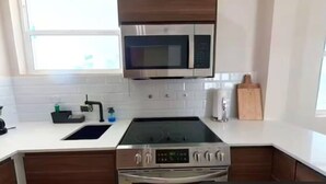 A modern kitchen with a built-in microwave, stove, and oven. - 3 Bedroom/2 Bathroom 1 block from the beach (San Juan)
