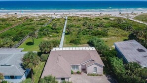 An aerial view of a coastal property with a long driveway leading to a house, surrounded by lush greenery and a beach in the background. - Direct Oceanfront ~ Private Walkway ~ Excellent Rates! (Saint Augustine)
