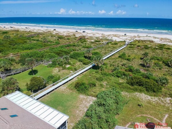 A coastal view with a bridge connecting two areas, a beach, and a building with a flat roof. - Direct Oceanfront ~ Private Walkway ~ Excellent Rates! (Saint Augustine)