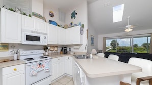 A modern kitchen with white cabinets, a built-in microwave, and a large island with seating. - Direct Oceanfront ~ Private Walkway ~ Excellent Rates! (Saint Augustine)