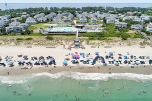 A coastal residential area with houses, a beach, and a lifeguard tower. - Walk to Beach & Pool, Resort Amenities, Pvt Deck (Corolla)