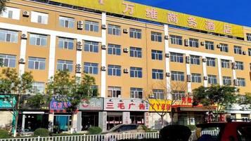 A multi-story building with a yellow facade and multiple windows.