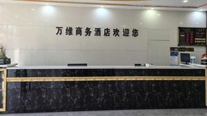 A hotel reception desk with a marble counter and a digital display board.