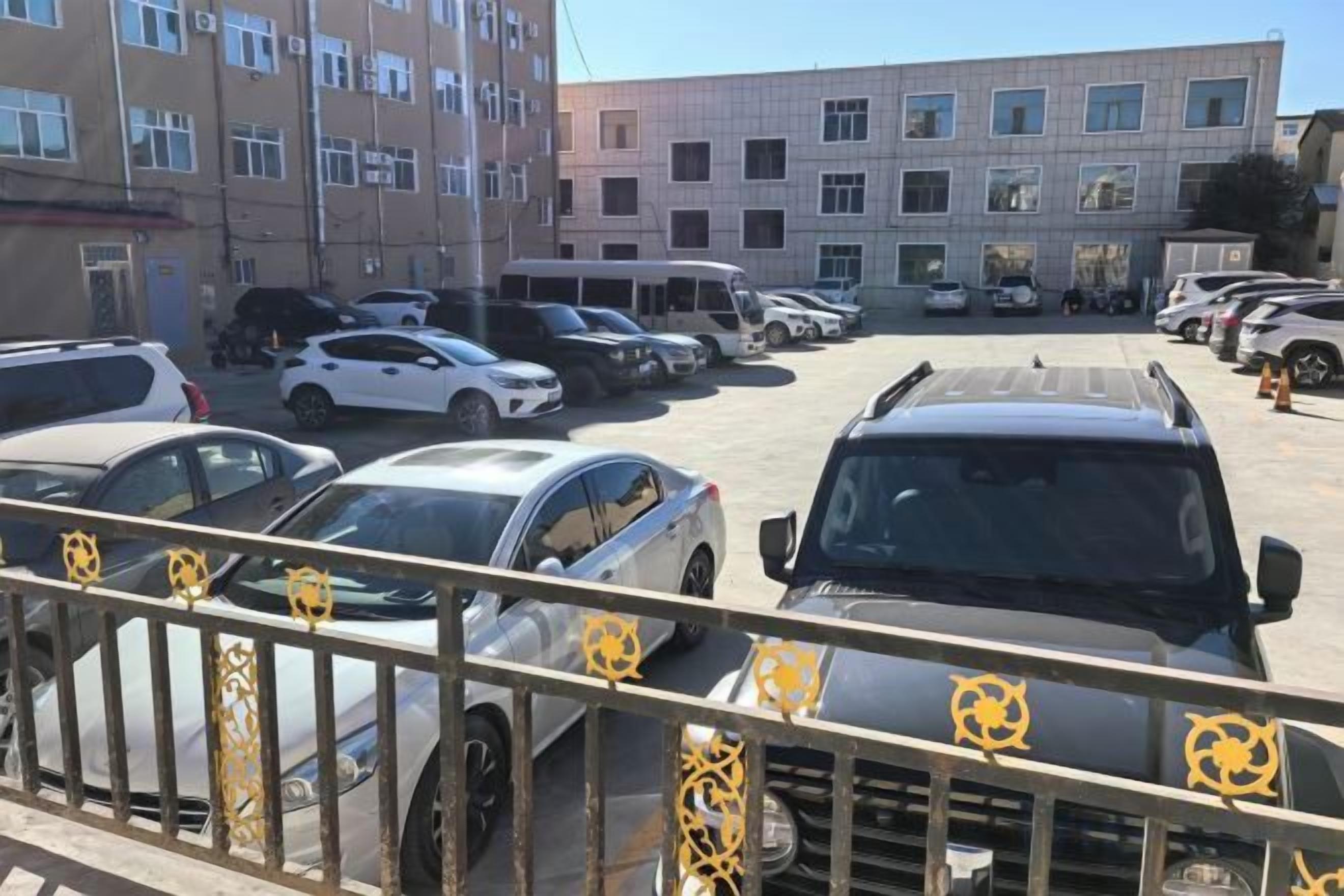 A parking lot with multiple cars and a building in the background.