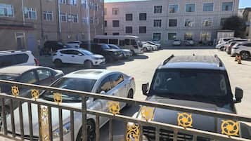 A parking lot with multiple cars and a building in the background.