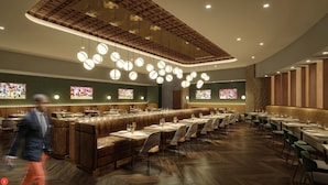Un restaurante moderno con una barra larga, asientos de cuero y diversas opciones de asientos.