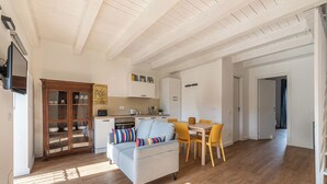 Uma sala de estar moderna com um sofá cinzento, cadeiras amarelas e uma mesa de jantar de madeira.