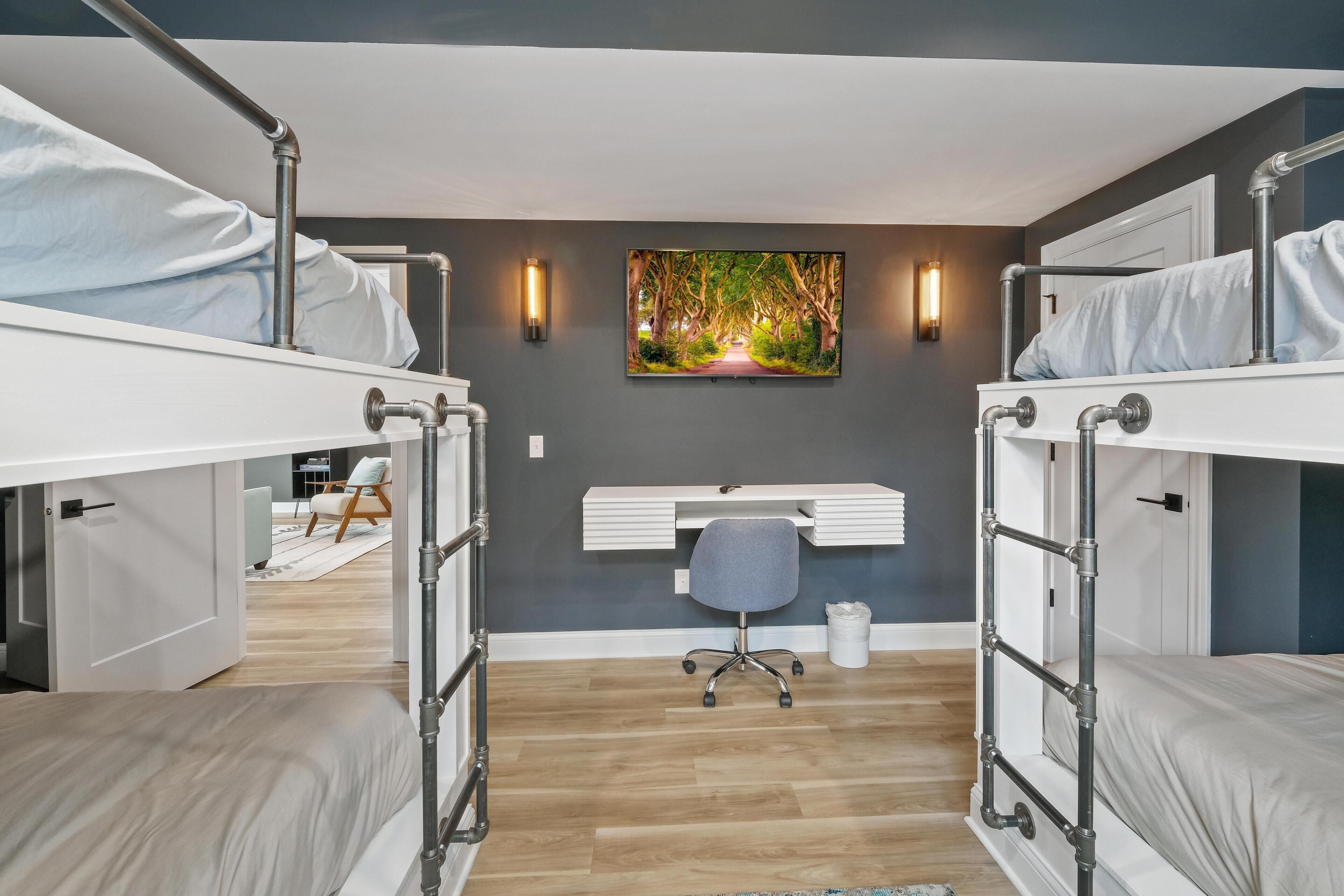 Une chambre avec des lits superposés, un bureau et une chaise.