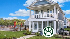 Une maison à deux étages avec un balcon, une cour arrière clôturée et une pancarte indiquant « ANIMAUX ACCEPTÉS ».