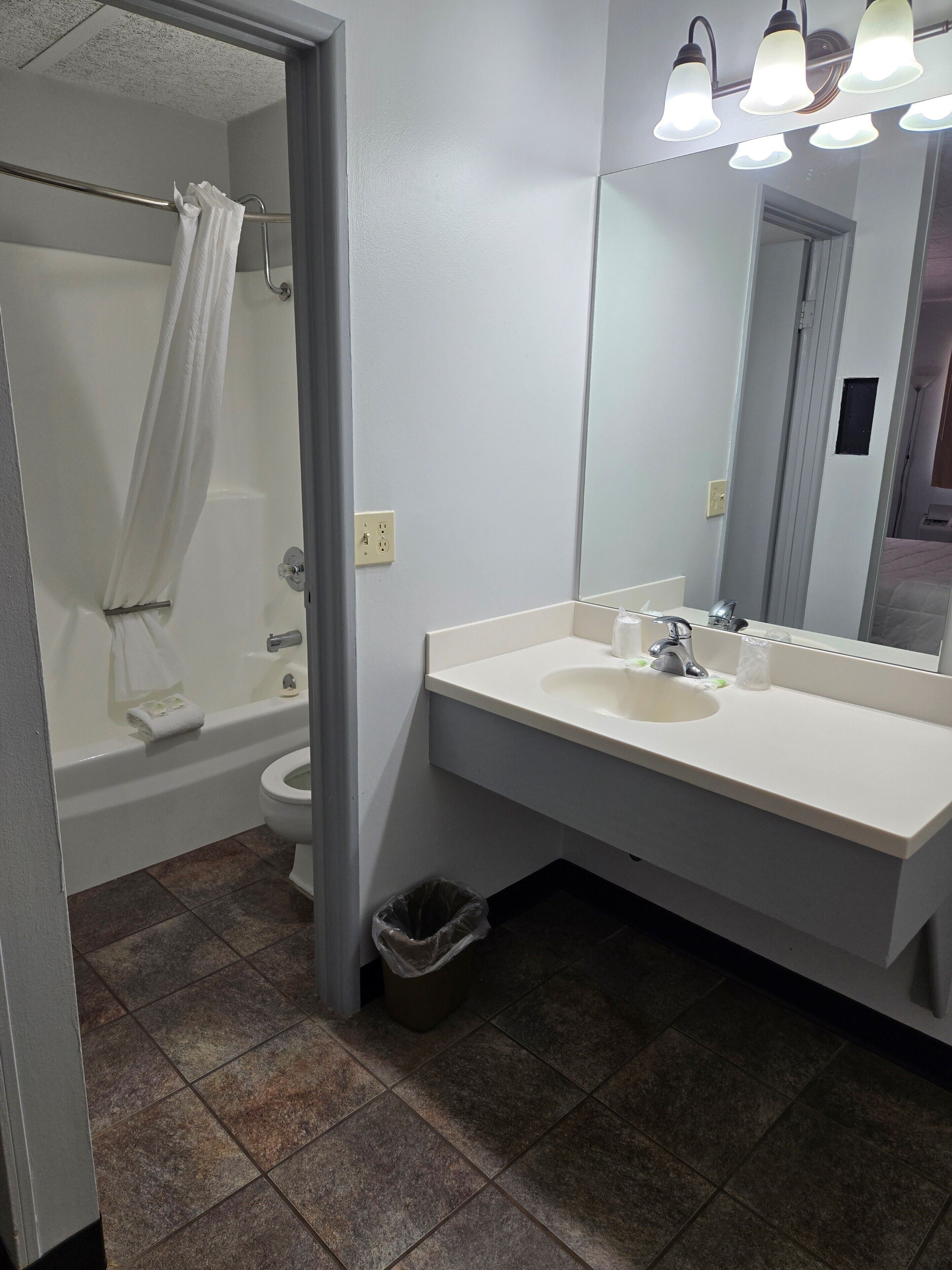 A bathroom with a bathtub, toilet, and sink.
