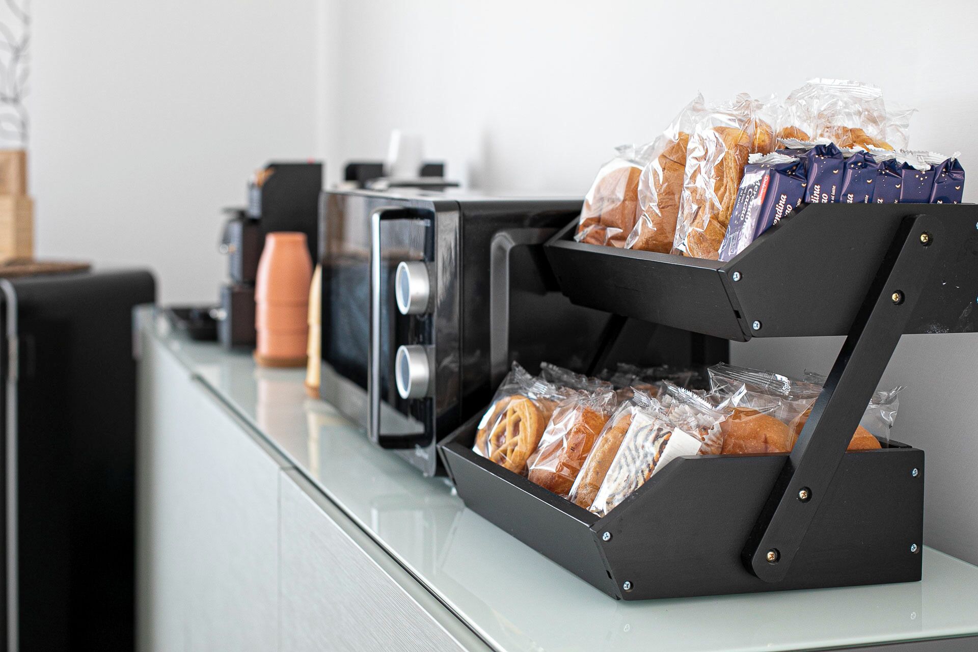 A breakfast station with a bread display and a coffee machine.