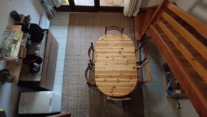Una cucina compatta con un tavolo da pranzo in legno, un forno incassato e una scala che conduce a un piano superiore.