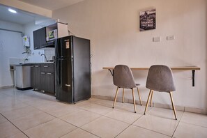 Frigorífico, microondas, utensilios de cocina y mesa de comedor