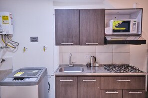 Frigorífico, microondas, utensilios de cocina y mesa de comedor