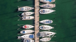 An aerial view of a marina with multiple boats docked in a row. - Köpmans - Boutique Hotel (Hoganas)