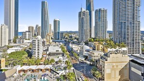 A cityscape with high-rise buildings, a prominent clock tower hotel, and a clear blue sky. - Central Twin Apartment with Ocean View - Q-Stay (Surfers Paradise)