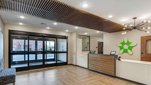 Zona de recepción con suelo de madera, mostrador de recepción y un gran ventanal que da al exterior.