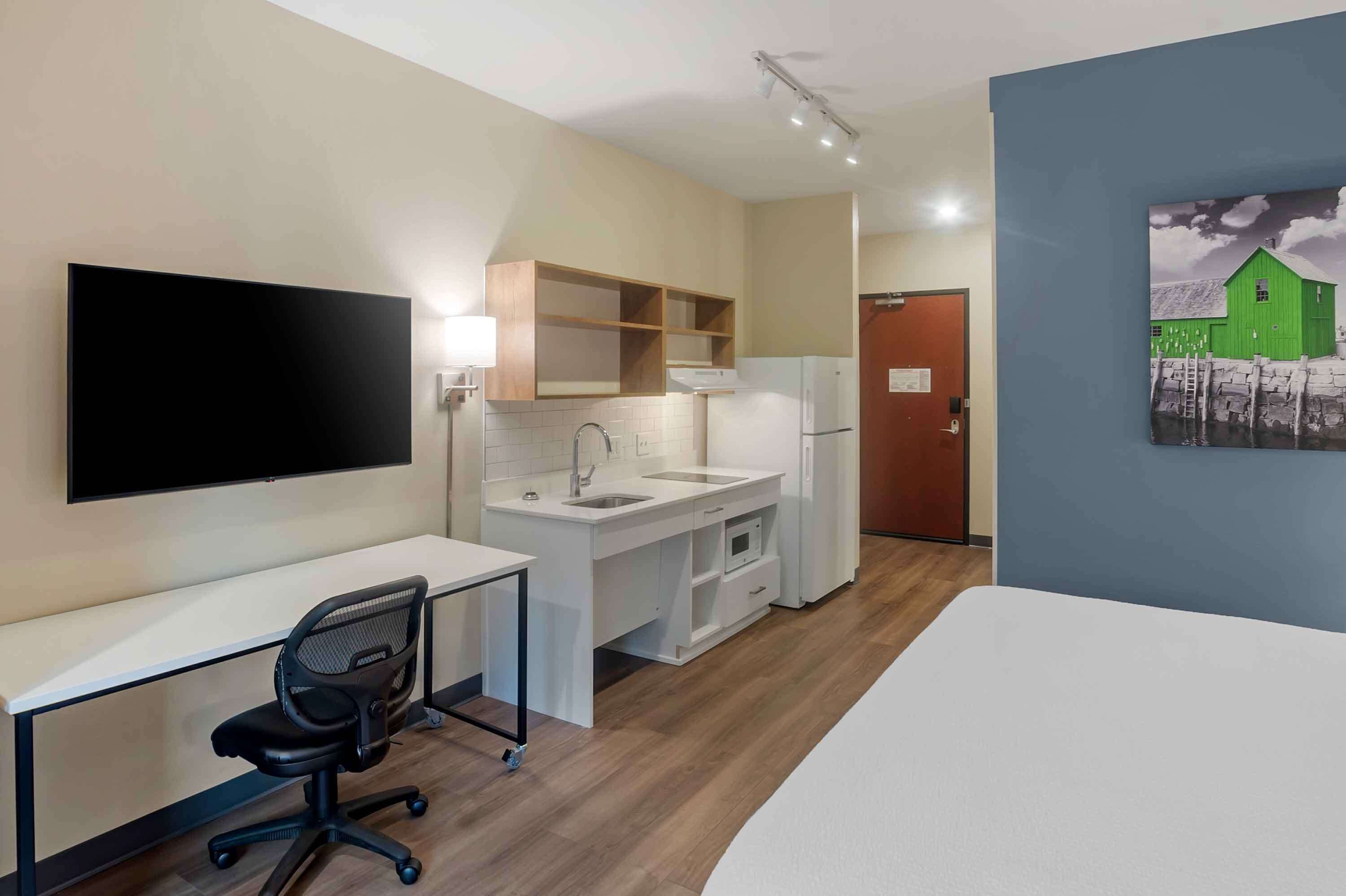 A compact kitchenette with a sink, microwave, and refrigerator.