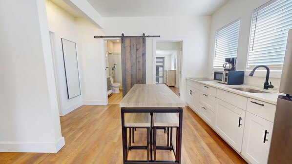 Een koelkast, een microgolfoven, een oven, kookgerei, borden en bestek