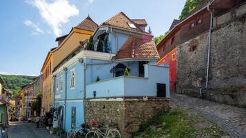Una calle adoquinada con edificios históricos, una bicicleta y un muro de piedra.