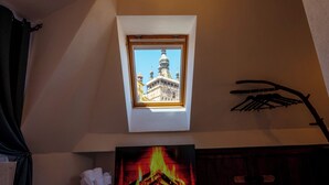 A room with a fireplace, a framed picture of a building, and a coat rack. - Blue House Citadel Sighisoara (Sighisoara)