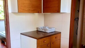A small kitchenette with wooden cabinets, a countertop, and a white appliance. - Apartment Tea 2 close to the beach and city center (Umag)