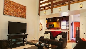 A living room with a TV, a sofa, a coffee table, and a red rug. - Stylish 2 BR & 2 bath + Loft Durango Condo near Purgatory (Durango)