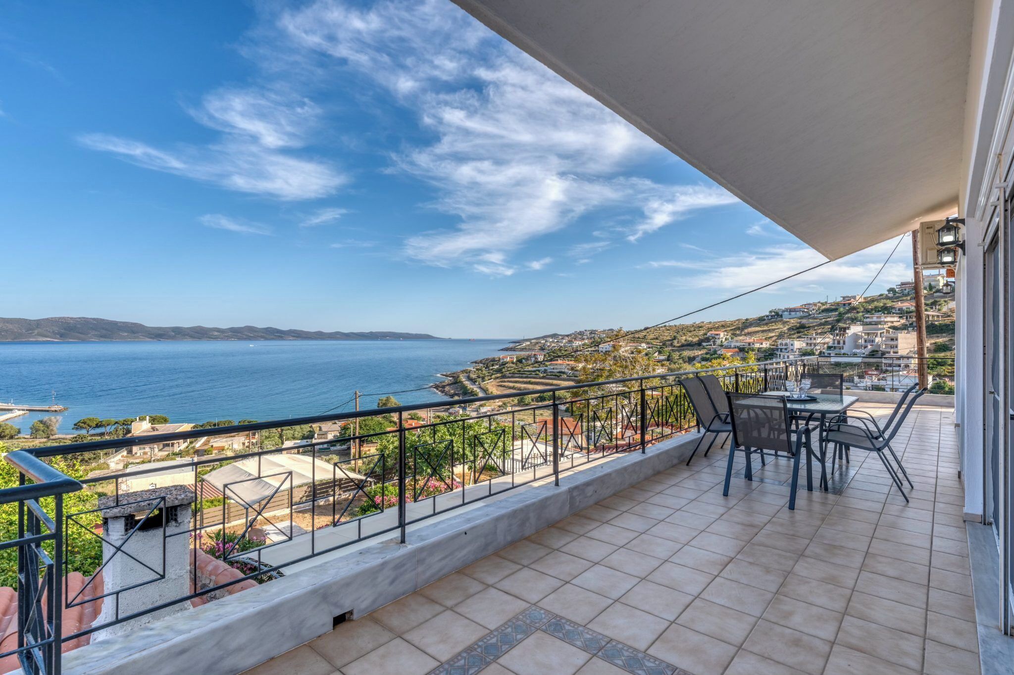 Un balcon avec vue sur la mer et sur la ville.