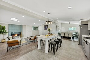 A spacious kitchen with a central island, modern appliances, and a dining area with chairs and a table. - BOOK NOW!!! Your vacation awaits your home for Disneyland and OC destinations. (Anaheim)
