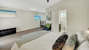 A bedroom with a large bed, a ceiling fan, a window, and a door. - BOOK NOW!!! Your vacation awaits your home for Disneyland and OC destinations. (Anaheim)